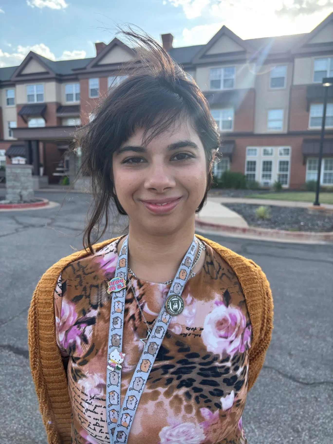 Abbey Joshi smiling outdoors in front of a Saddlebrook Senior Living building